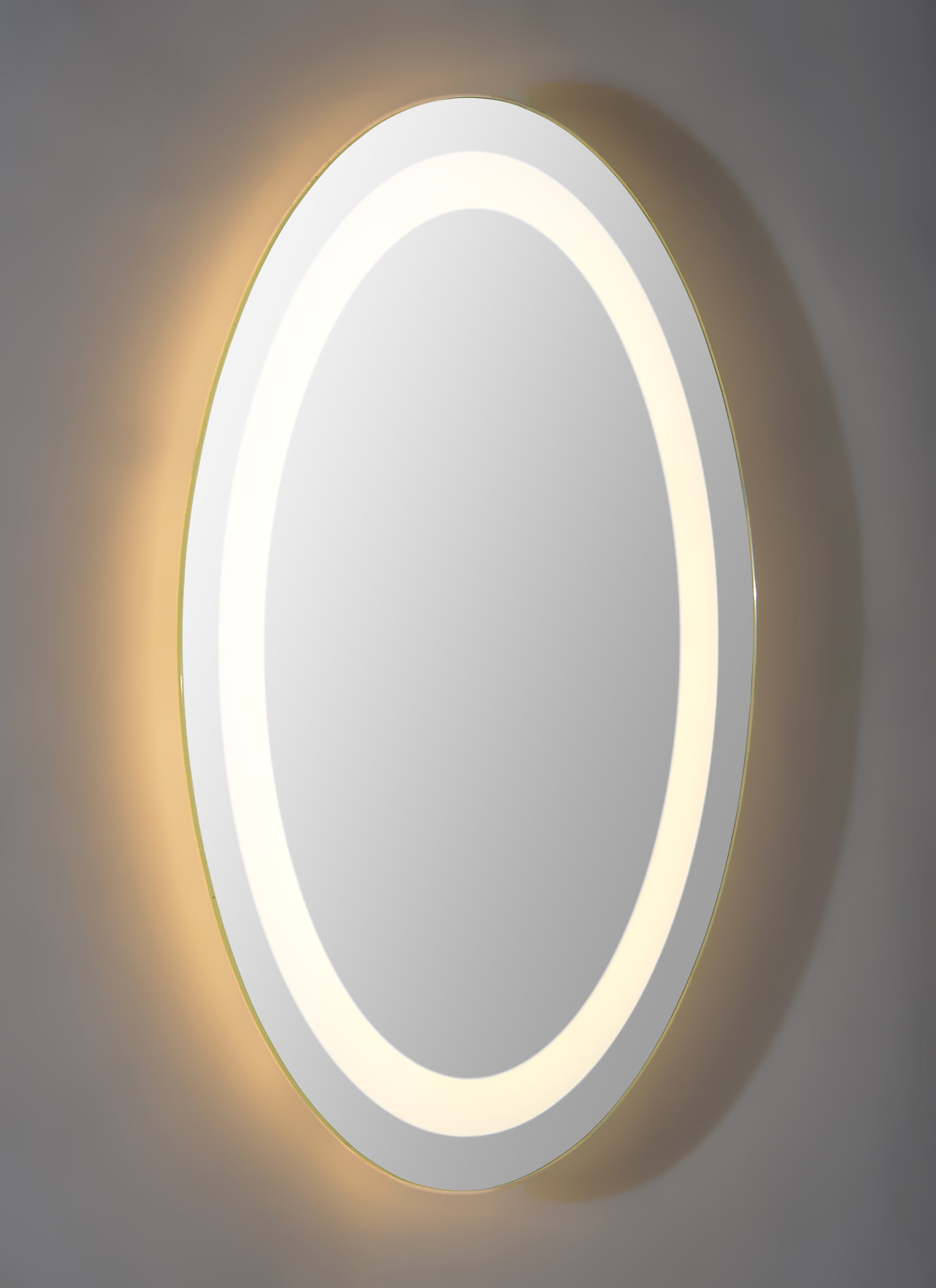 Oval shaped frame less back lit mirror.